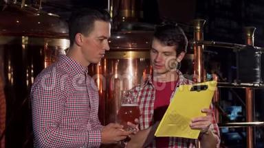 两名酿酒师在酿酒厂检验工艺啤酒